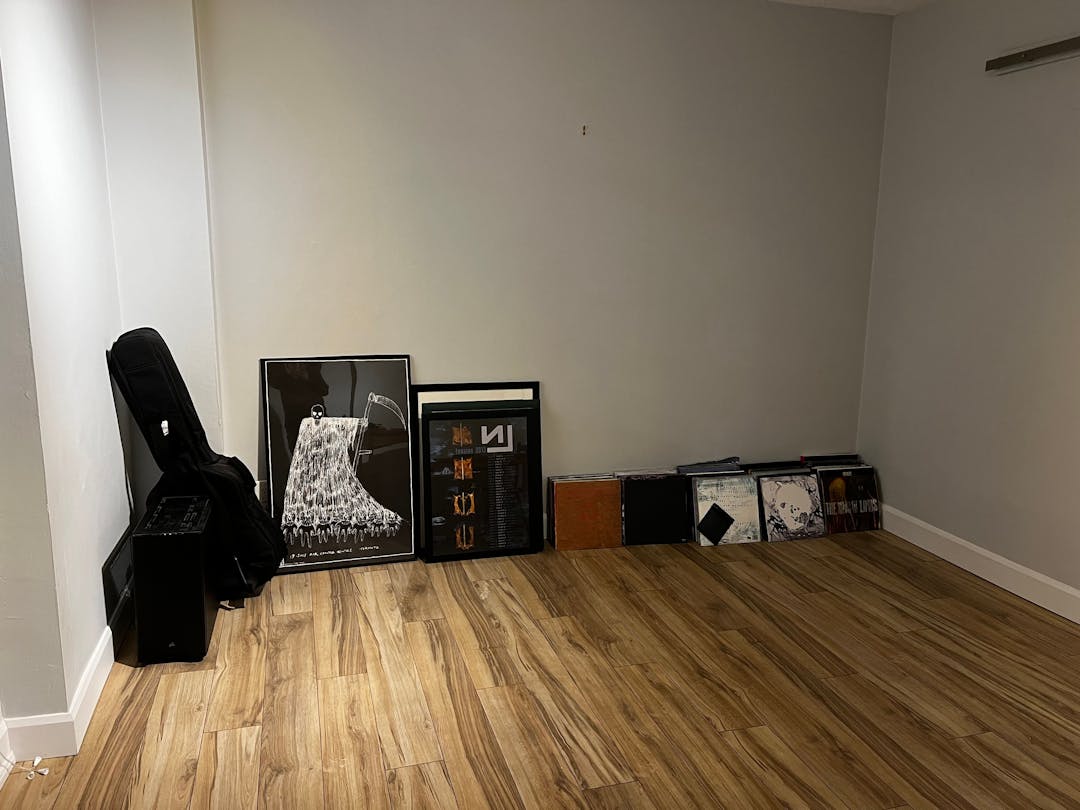 framed posters and vinyl records on the floor against the wall